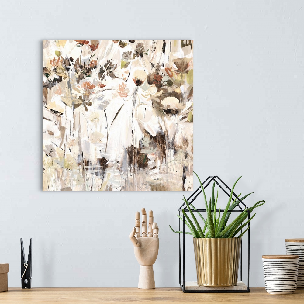 A bohemian room featuring Square abstract painting with neutral colors and pops of brighter hues resembling flowers.