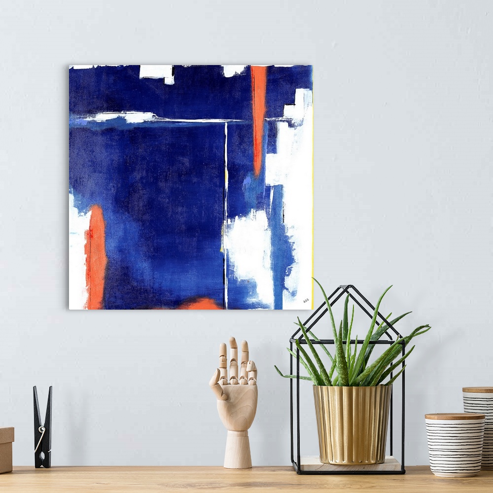 A bohemian room featuring Square abstract art with heavy blue hues on the background and bright orange, white, and yellow l...