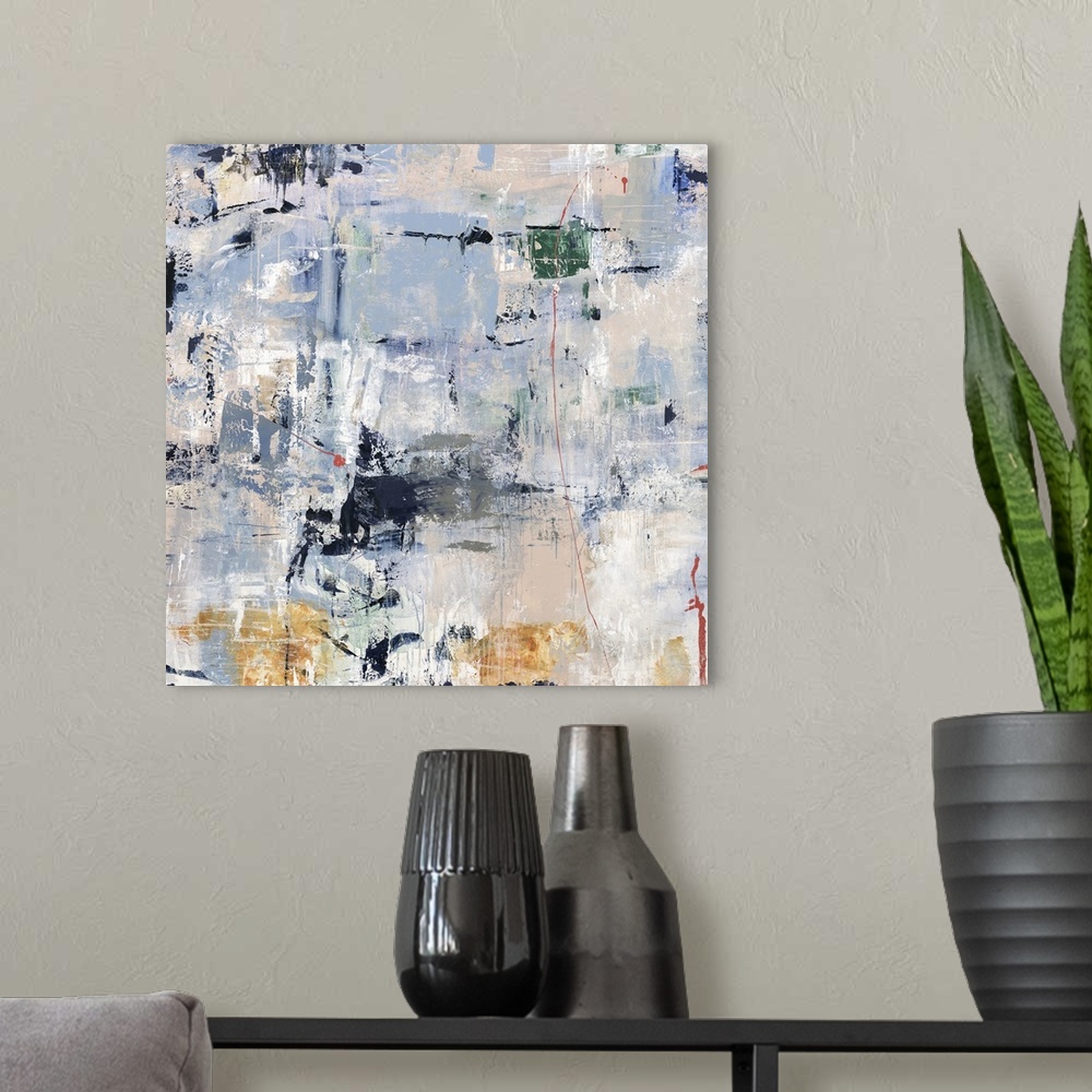 A modern room featuring Square abstract artwork in shades of blue with pops of emerald green, coral,  gray, and gold.