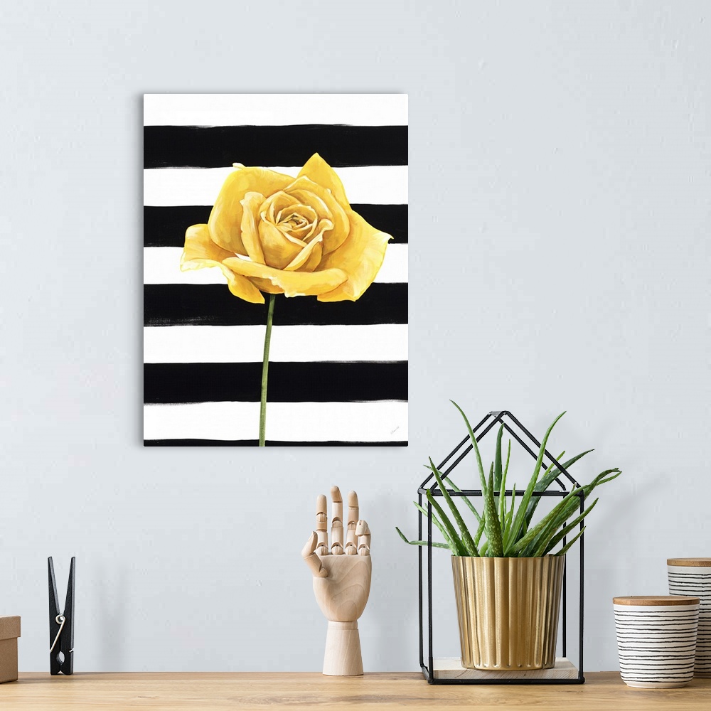 A bohemian room featuring A single yellow rose over a black and white striped background.