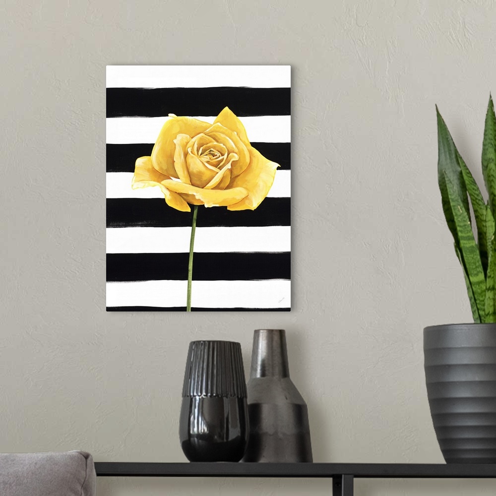 A modern room featuring A single yellow rose over a black and white striped background.