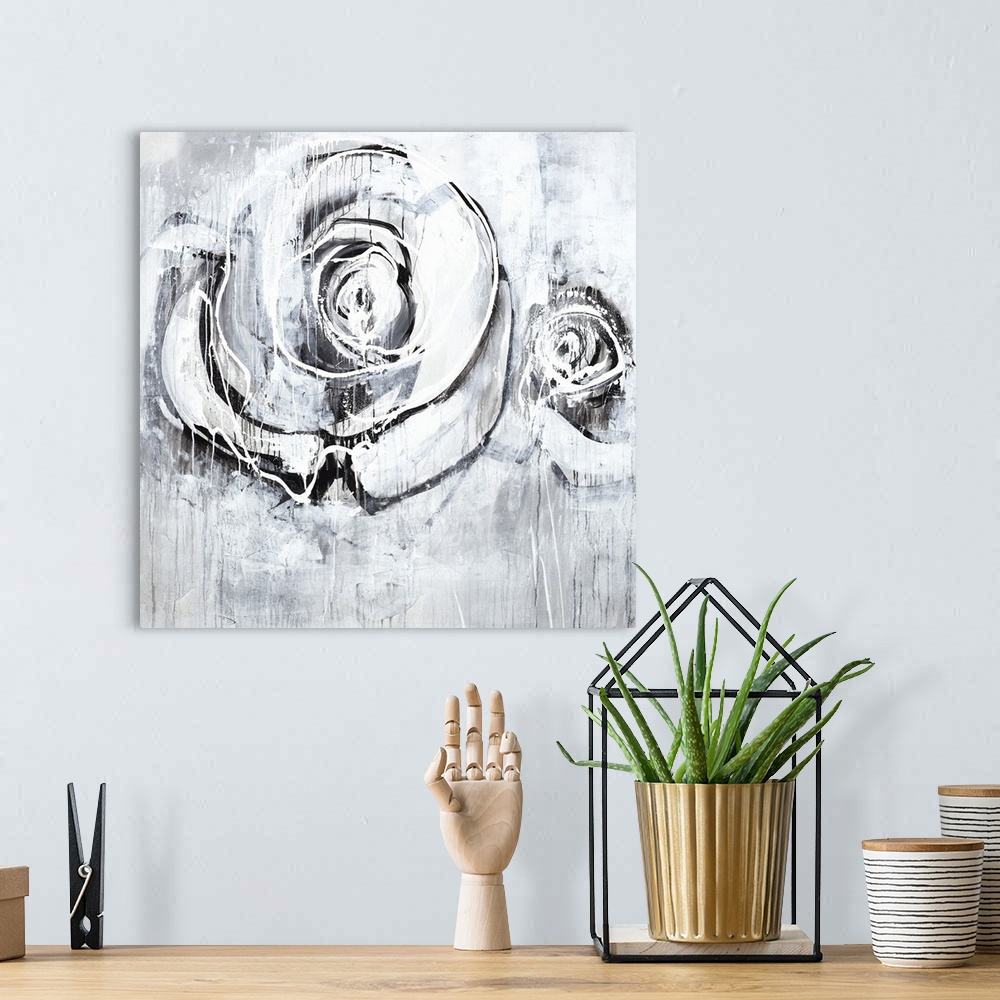 A bohemian room featuring Square artwork of two roses in textured paint on shades of gray.