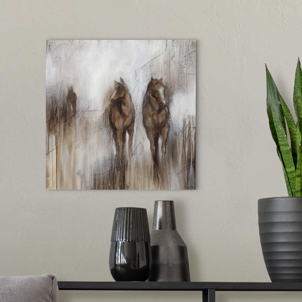 A modern room featuring Artwork of three horses grazing together in a field of brown on an early foggy morning.