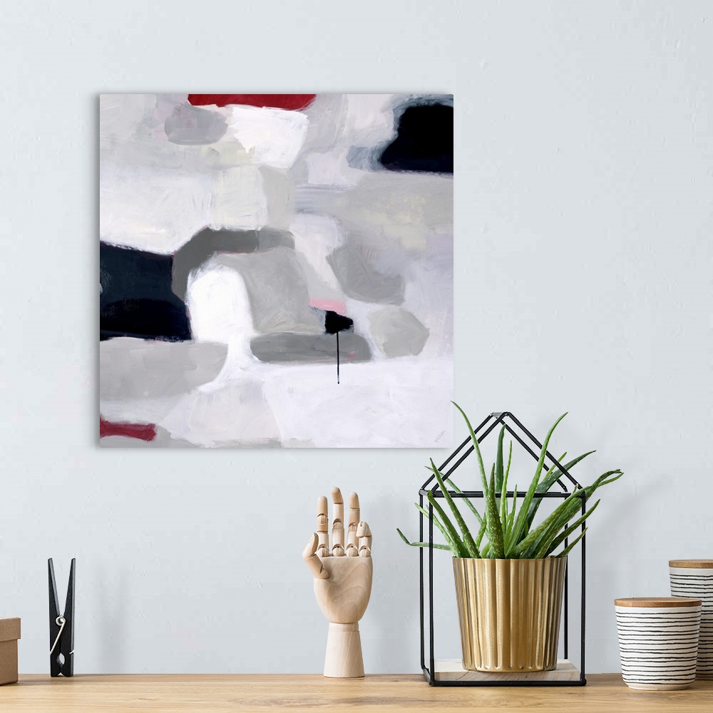 A bohemian room featuring Abstract square painting of shades of gray with accent colors of red and black.