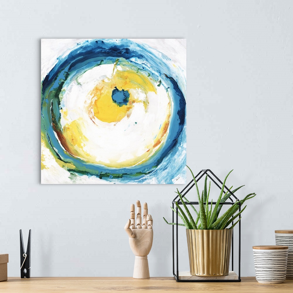 A bohemian room featuring Square abstract artwork with a large circle in the center with blue, green, yellow, and orange br...