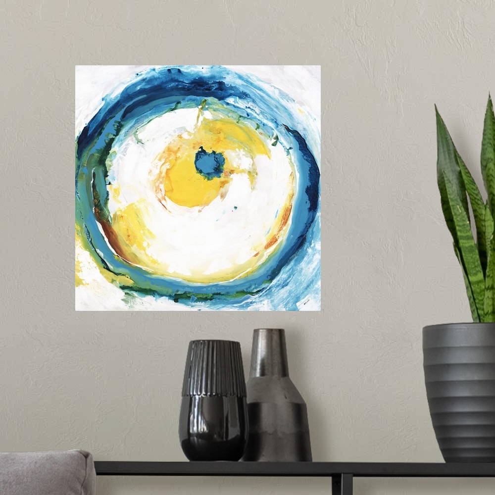 A modern room featuring Square abstract artwork with a large circle in the center with blue, green, yellow, and orange br...