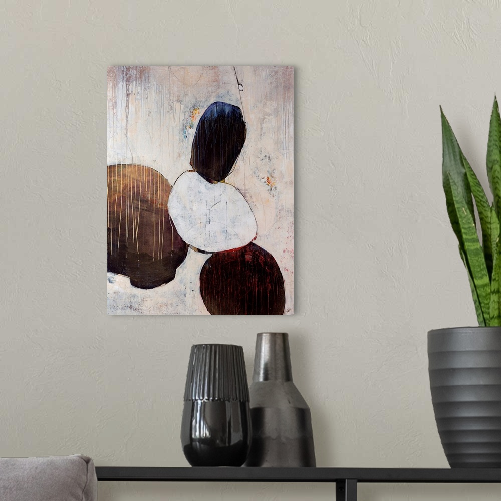 A modern room featuring Abstract artwork that consists of four large rounded objects that has paint from the top of the p...