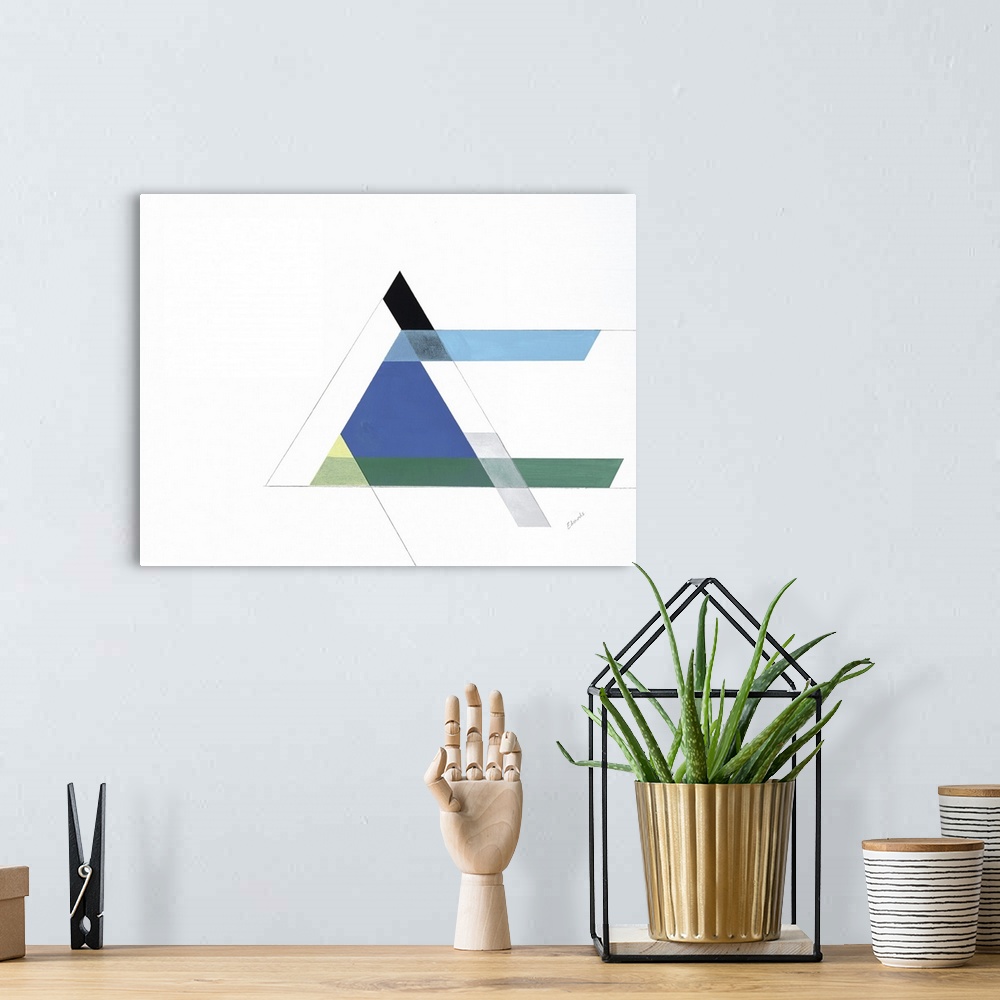 A bohemian room featuring A simple artwork of geometric shapes of a triangle in blue and green.