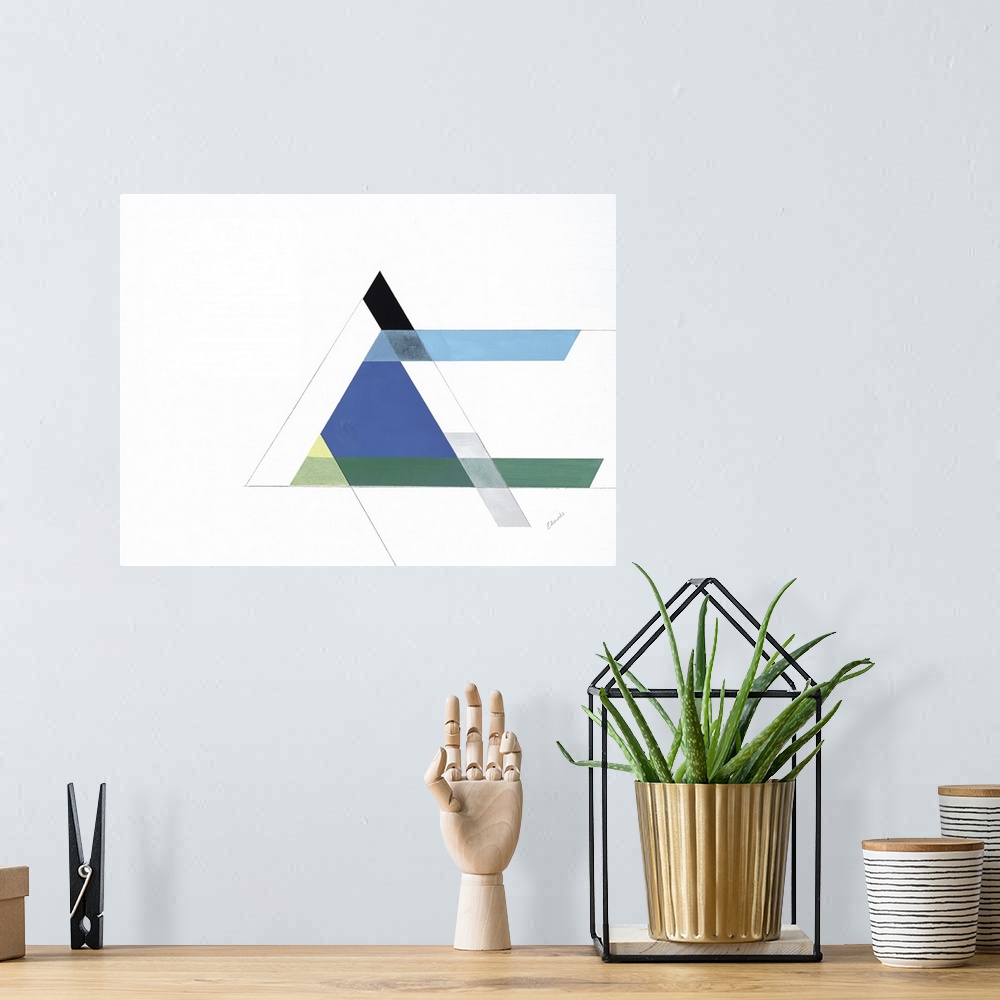 A bohemian room featuring A simple artwork of geometric shapes of a triangle in blue and green.