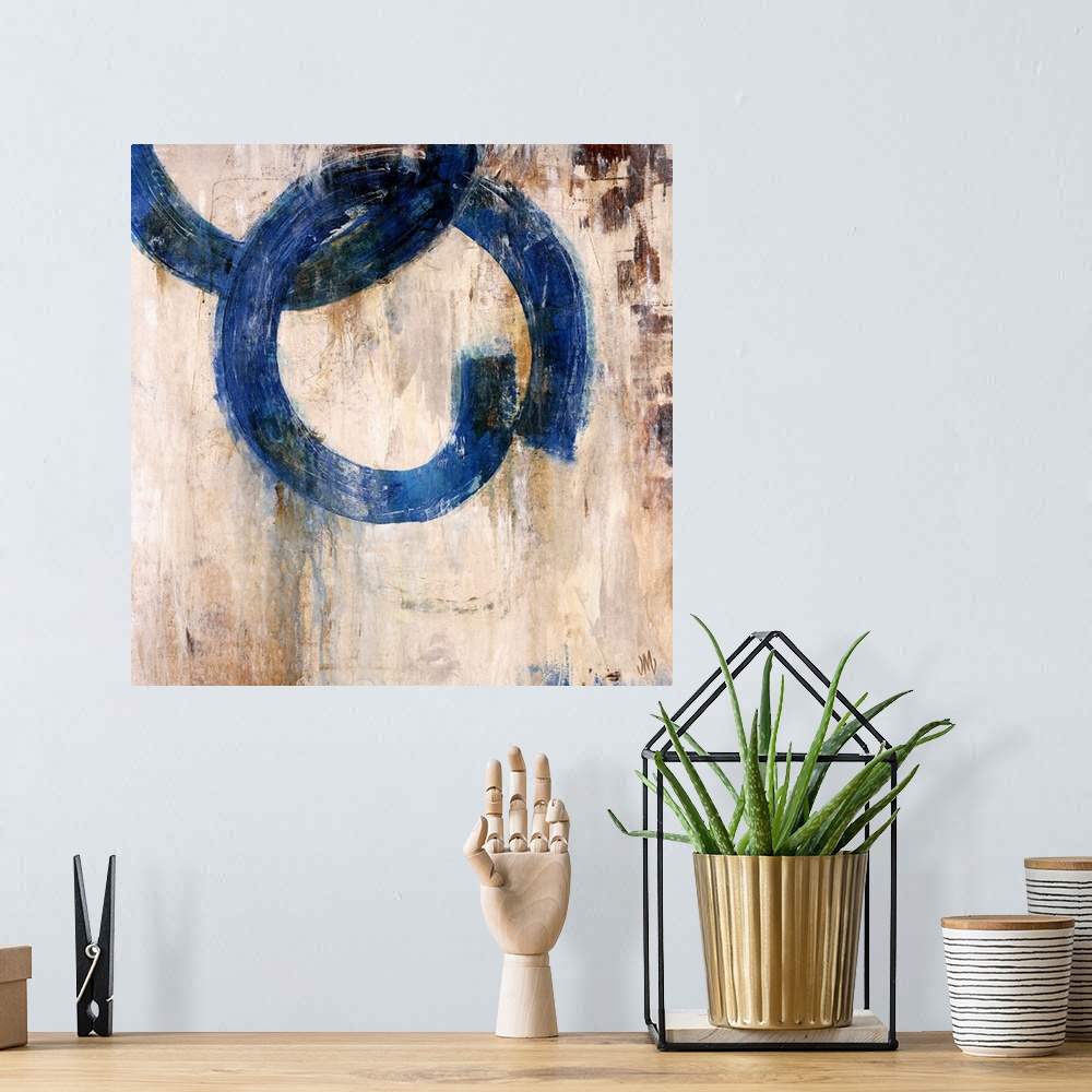 A bohemian room featuring Abstract artwork of a mostly neutral background that has two blue rings that are interlocked.