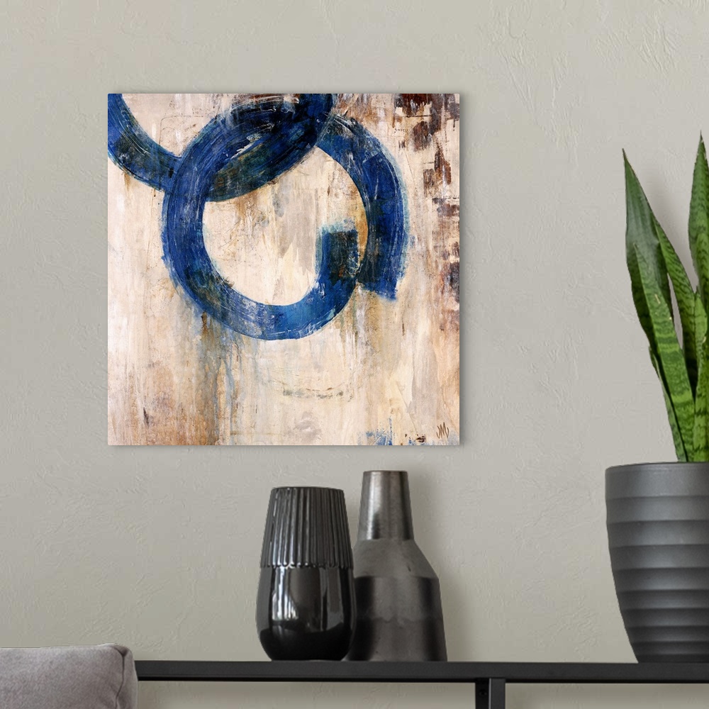 A modern room featuring Abstract artwork of a mostly neutral background that has two blue rings that are interlocked.