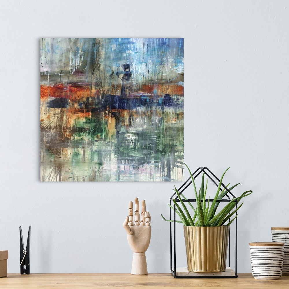 A bohemian room featuring Square abstract painting with various hues and streaks falling from top to bottom.