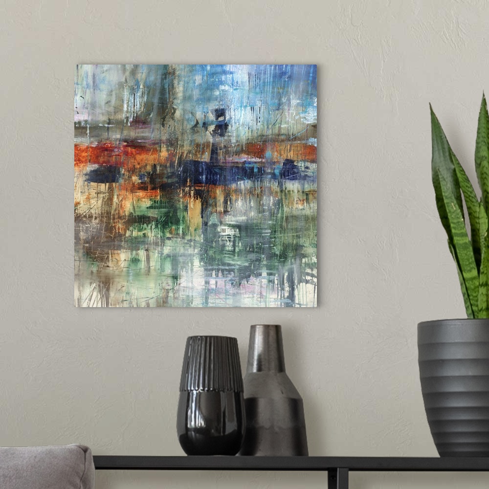 A modern room featuring Square abstract painting with various hues and streaks falling from top to bottom.