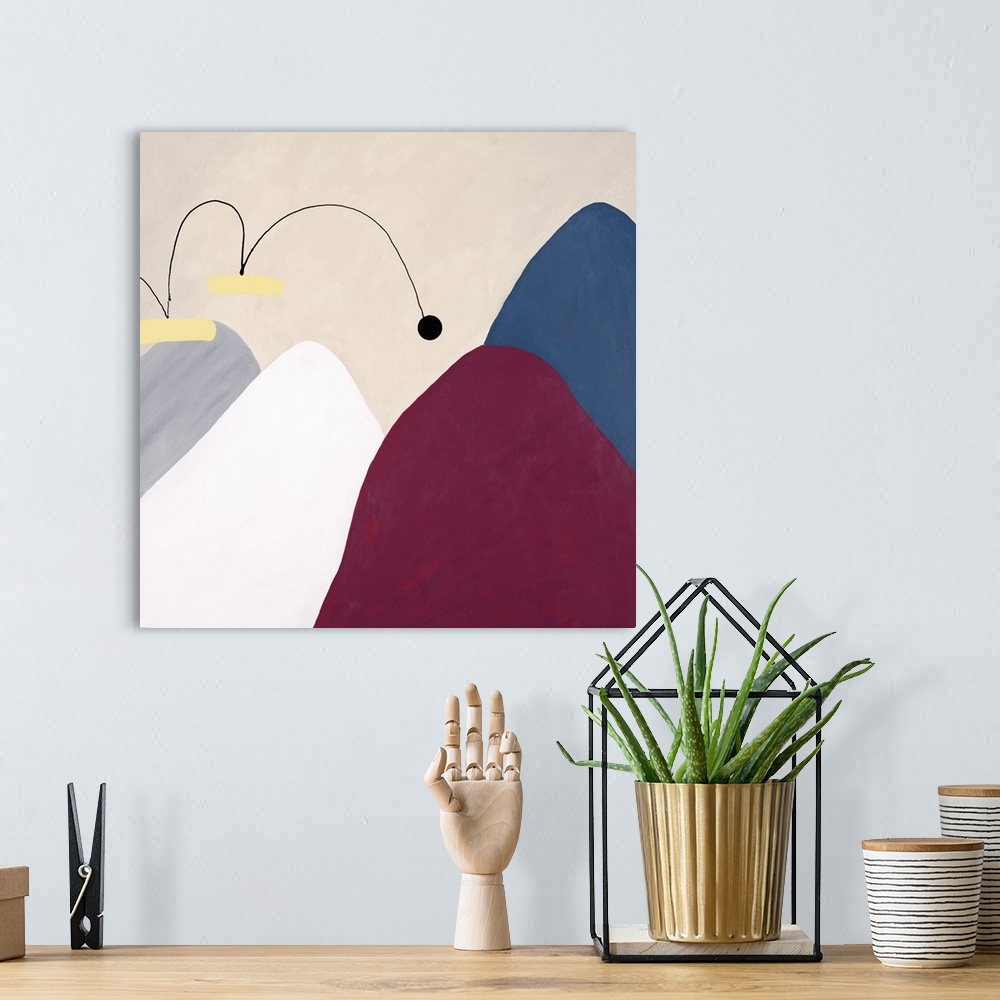 A bohemian room featuring Contemporary abstract art of several mountains, each different in color, with a small ball that a...