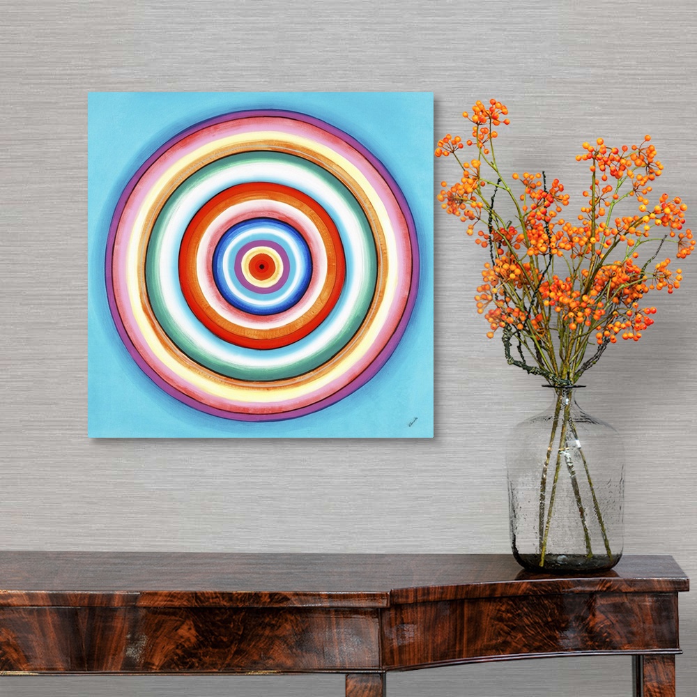 A traditional room featuring A contemporary painting of concentric circles in a variety of colors against a light blue backgro...
