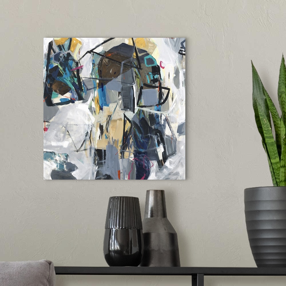 A modern room featuring Square abstract art with colorfully compiled, loose, geometric shapes surrounded by shades of gray.
