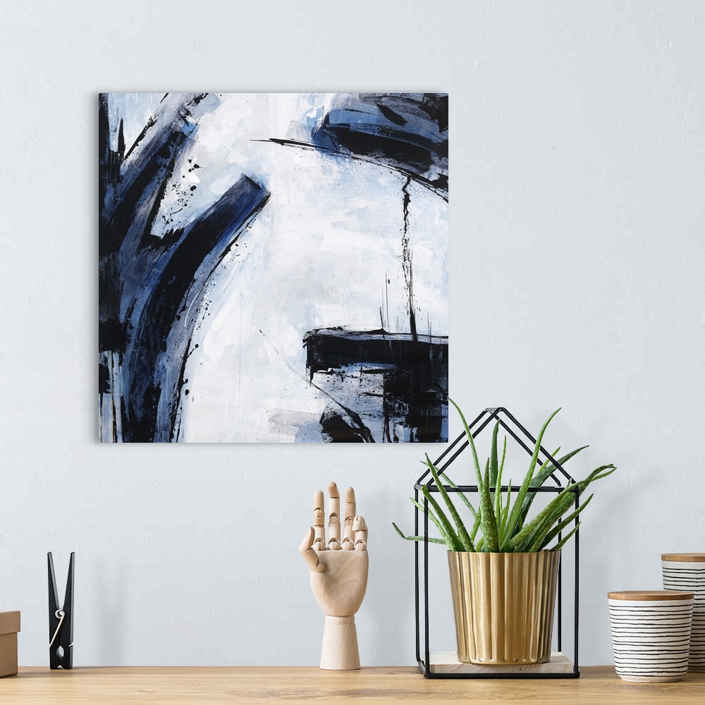 A bohemian room featuring Abstract painting using dark blue and black colors against a pale blue blue background.
