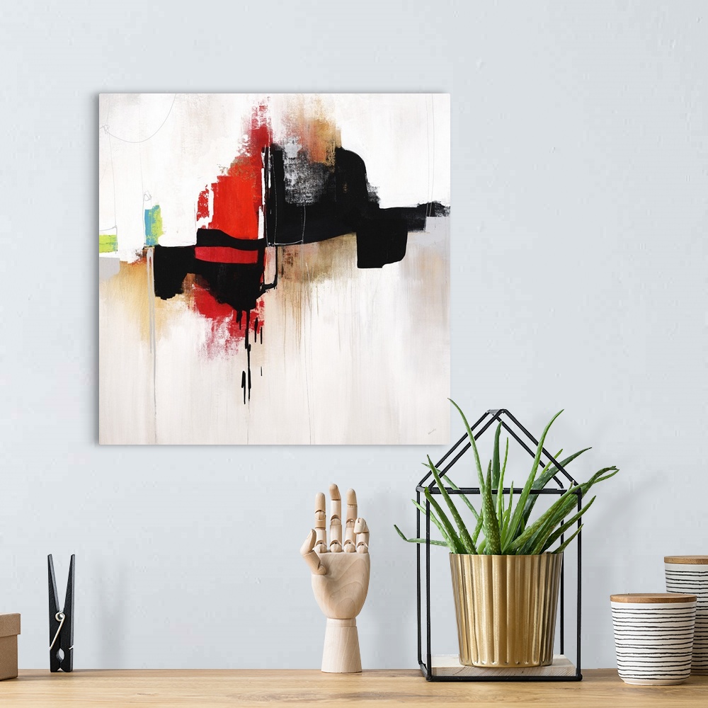 A bohemian room featuring Square abstract art with bold black and red designs in the middle and gold and silver hues drippi...