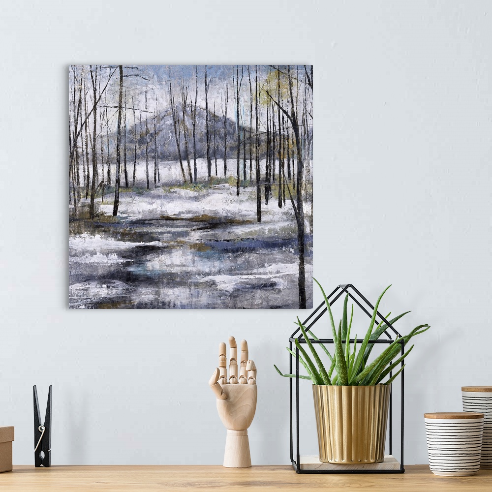A bohemian room featuring Contemporary painting of a Winter landscape with bare trees, snow on the ground, and a mountain i...