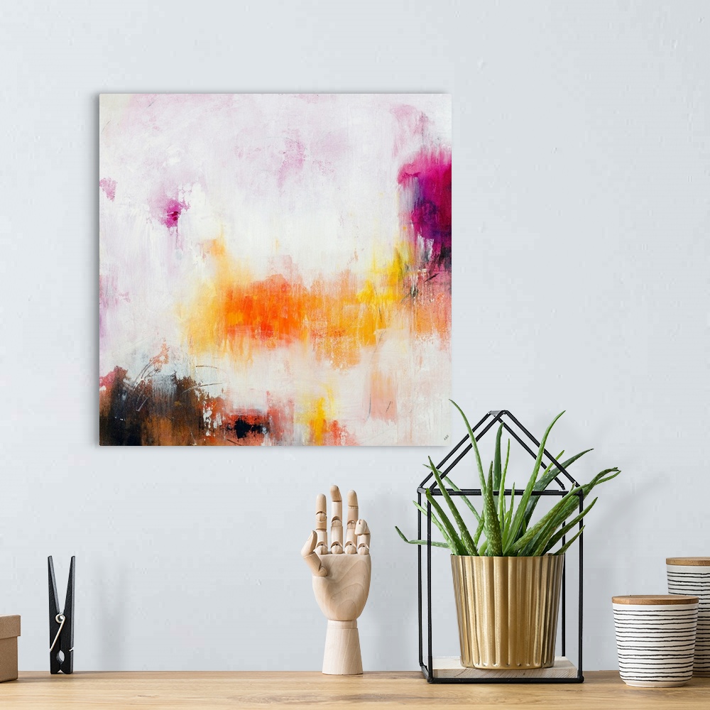 A bohemian room featuring Large abstract painting in warm pink, purple, yellow, and orange hues on a square canvas.