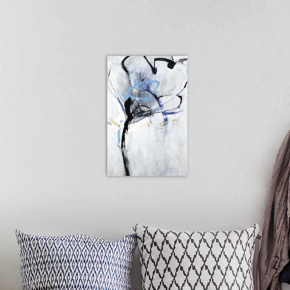 A bohemian room featuring An abstract floral painting with colors of blue and yellow along with the light gray background.