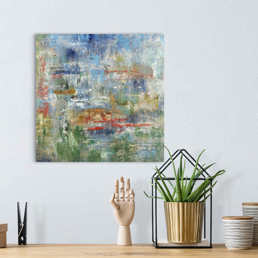 A bohemian room featuring Square abstract painting in blue, green, red, gold, and gray hues.