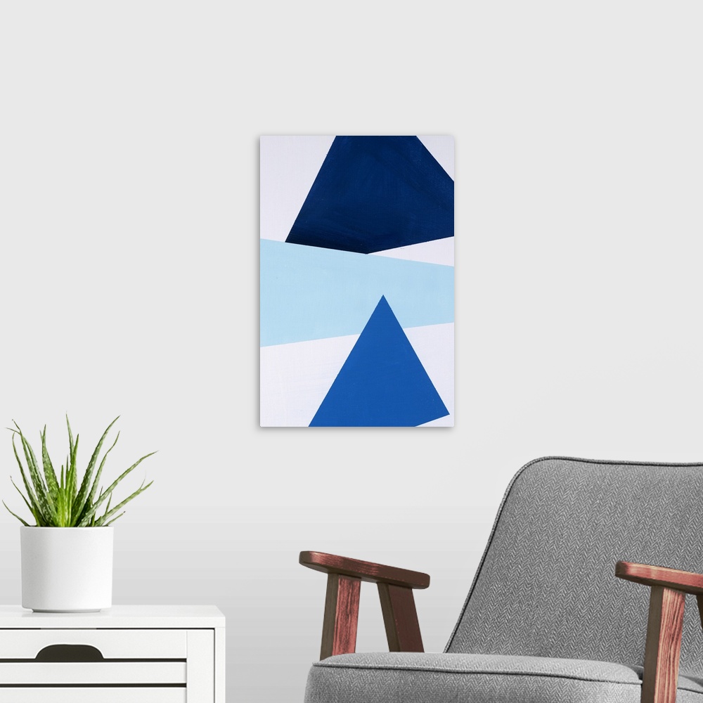 A modern room featuring Geometric abstract painting that has a white background with three large triangular shapes stacke...