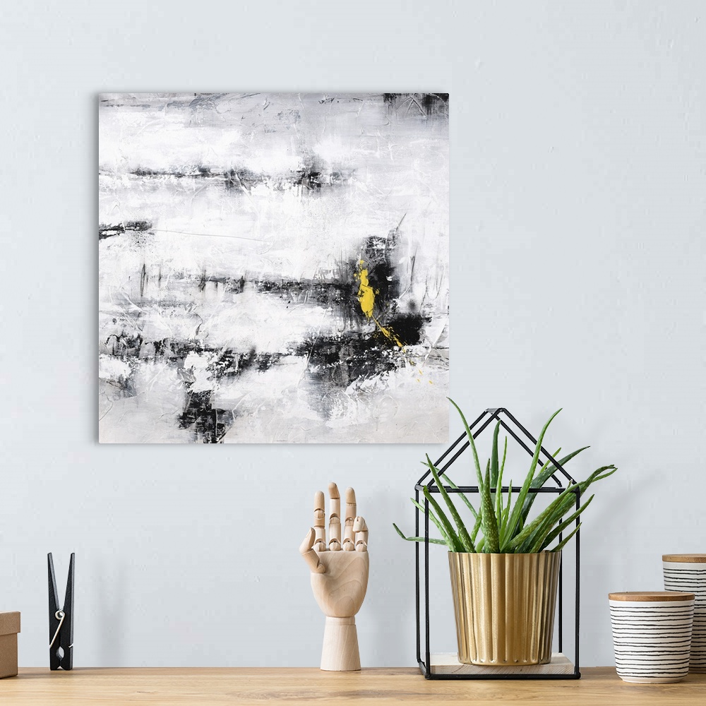 A bohemian room featuring Square abstract art in black, white, and gray with a pop of bright yellow on the bottom right side.