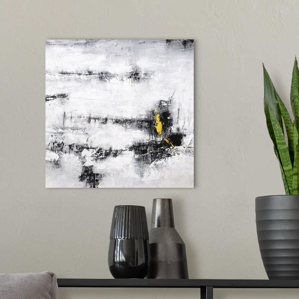 A modern room featuring Square abstract art in black, white, and gray with a pop of bright yellow on the bottom right side.
