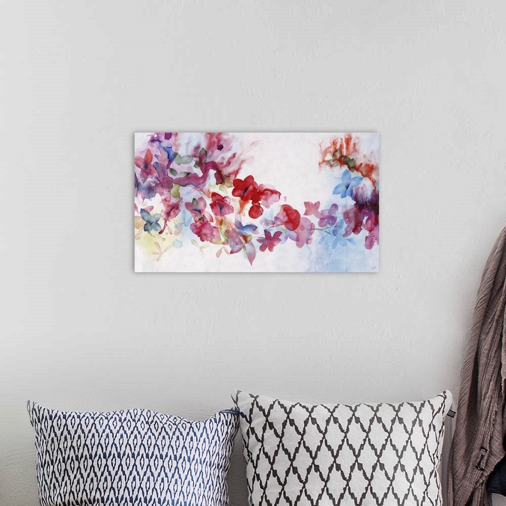 A bohemian room featuring Large horizontal artwork of colorful flowers of red, pink and blue fading into the white background.