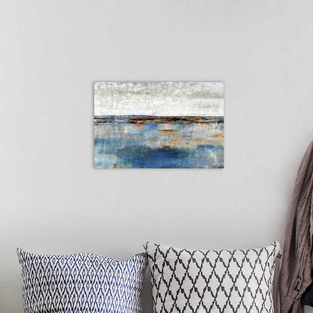A bohemian room featuring Contemporary artwork of a blue landscape under a white cloudy sky.