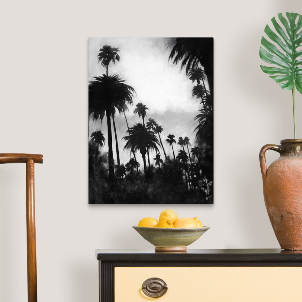 A traditional room featuring A black and white contemporary painting of a tree line of palm trees against of cloudy sky.