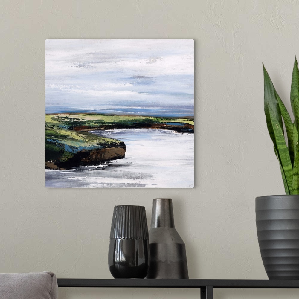 A modern room featuring Landscape painting of a curving shoreline that rises above the water, beneath a blue sky streaked...