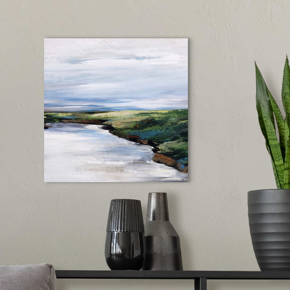 A modern room featuring Landscape painting of a curving shoreline that rises above the water, beneath a blue sky streaked...