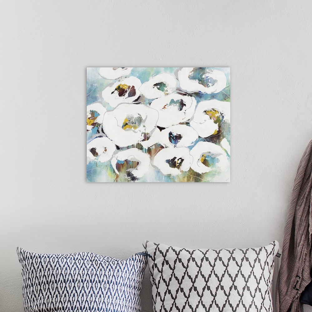 A bohemian room featuring An abstract floral painting of white flowers with a multi-color background.