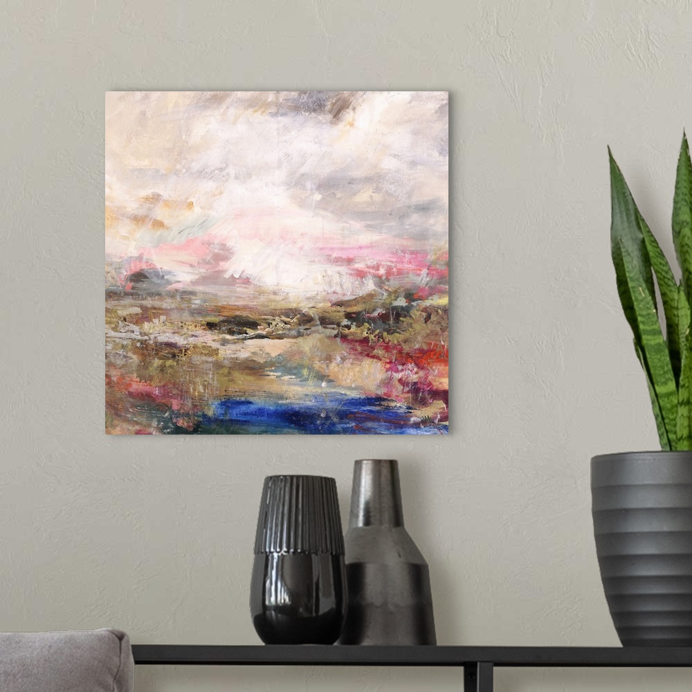 A modern room featuring Square abstract painting with warm pink, orange, and gold tones and pops of cool blue and green a...