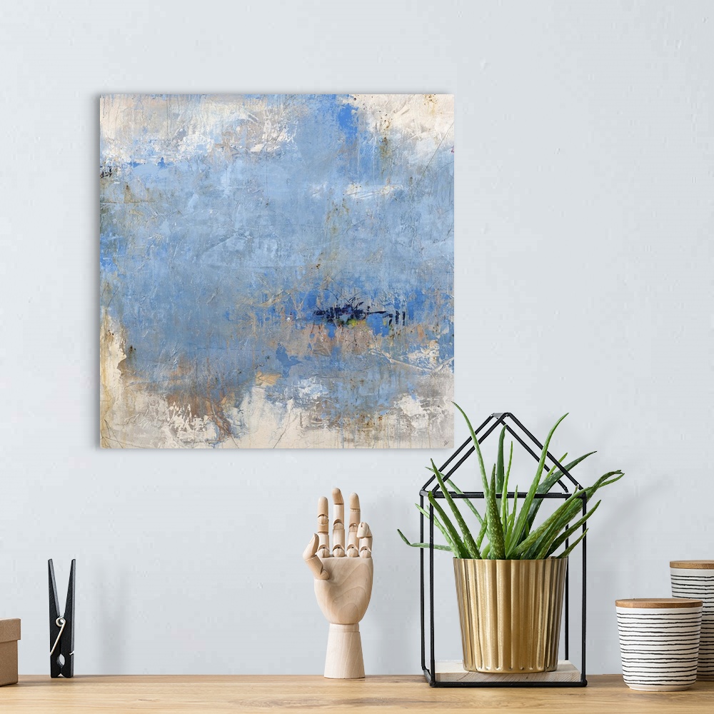 A bohemian room featuring Square abstract painting in cool shades of blue an gray with small hits of yellow and red.