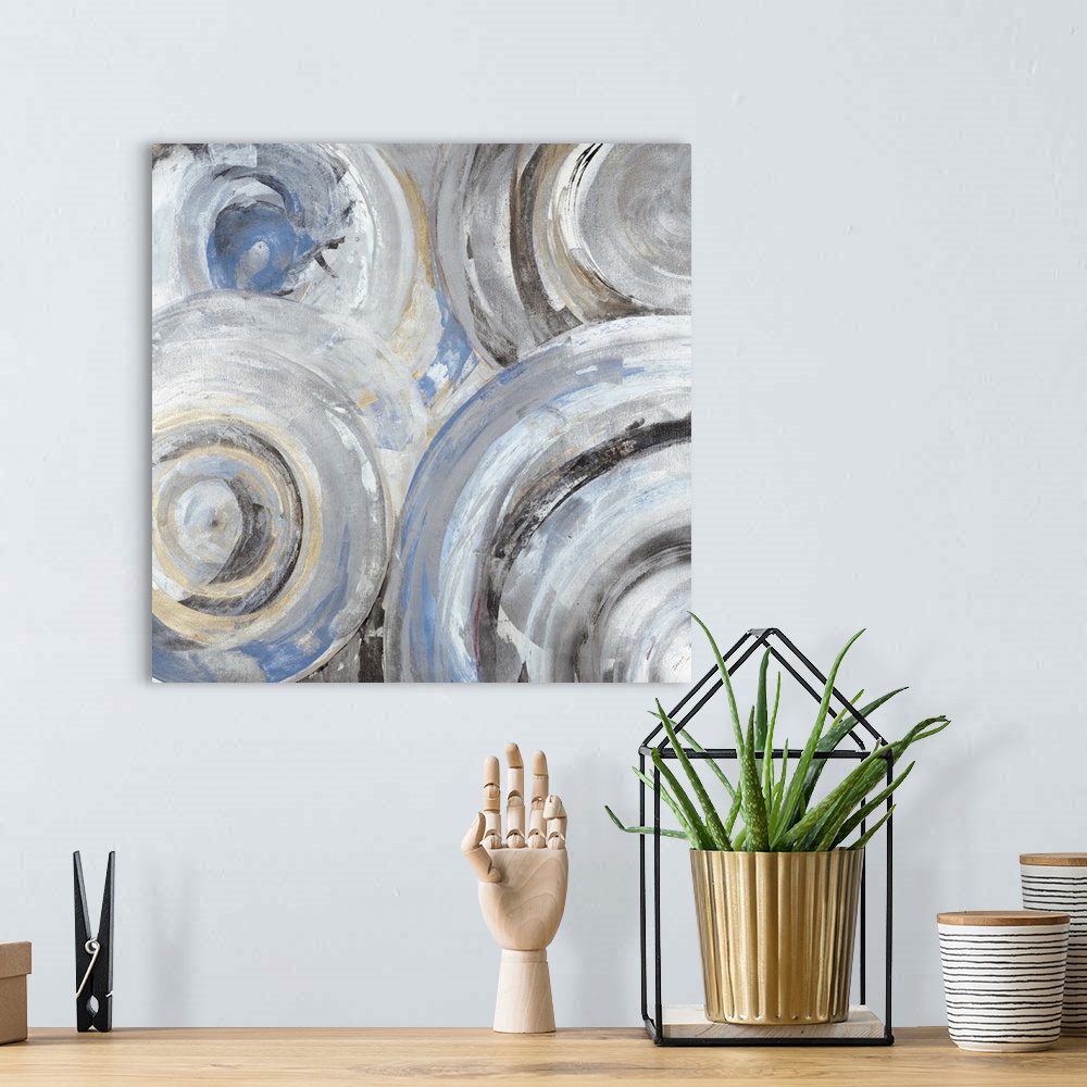 A bohemian room featuring Contemporary abstract painting of circle with concentric rings in light blue and gray tones.