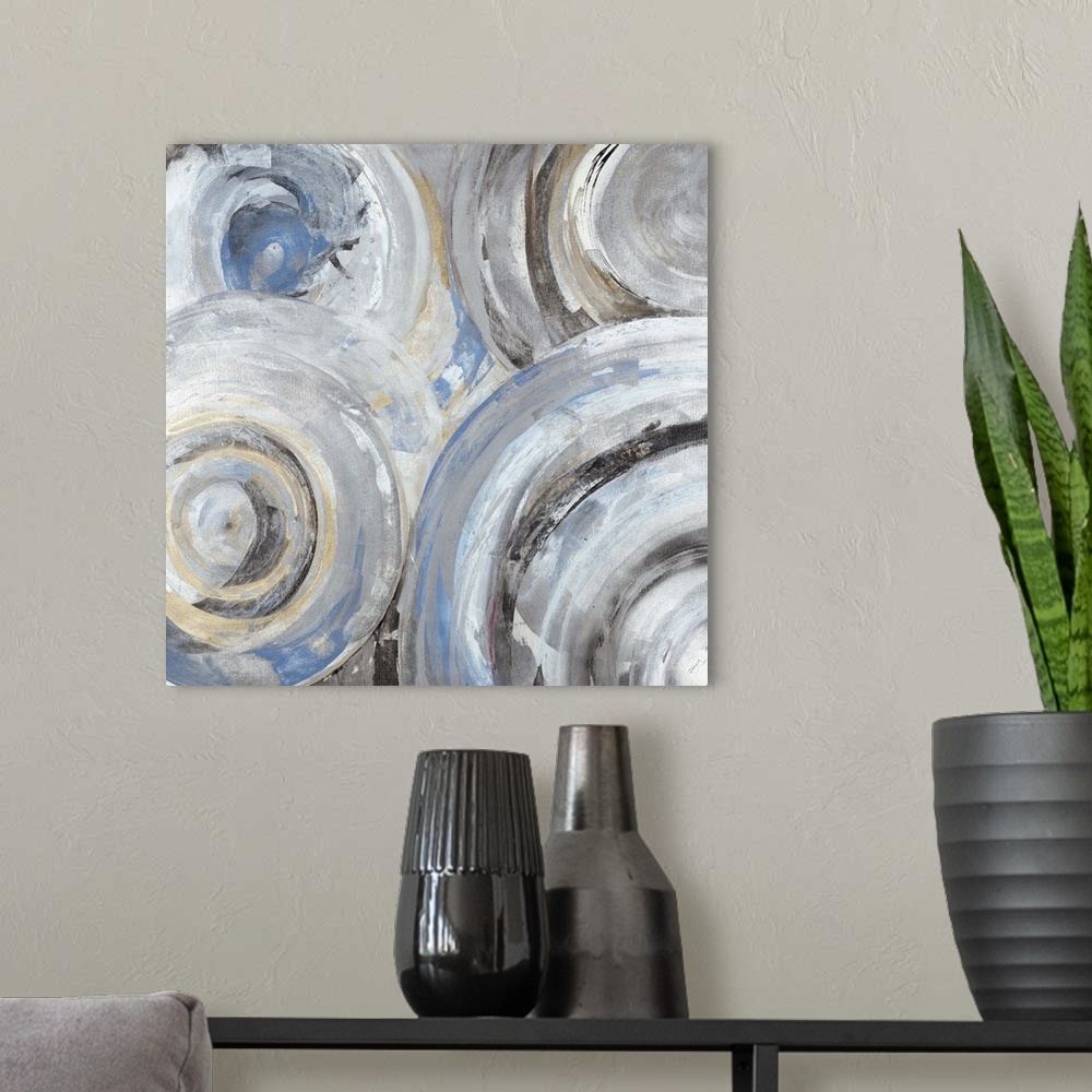 A modern room featuring Contemporary abstract painting of circle with concentric rings in light blue and gray tones.