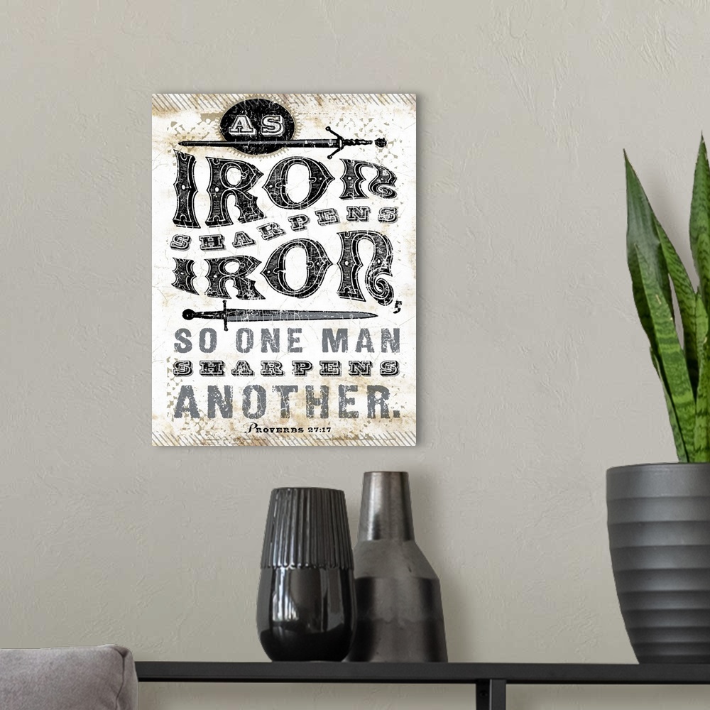 A modern room featuring Distressed lettering of the scripture bible verse Proverbs 27:17 As iron sharpens iron, so one ma...