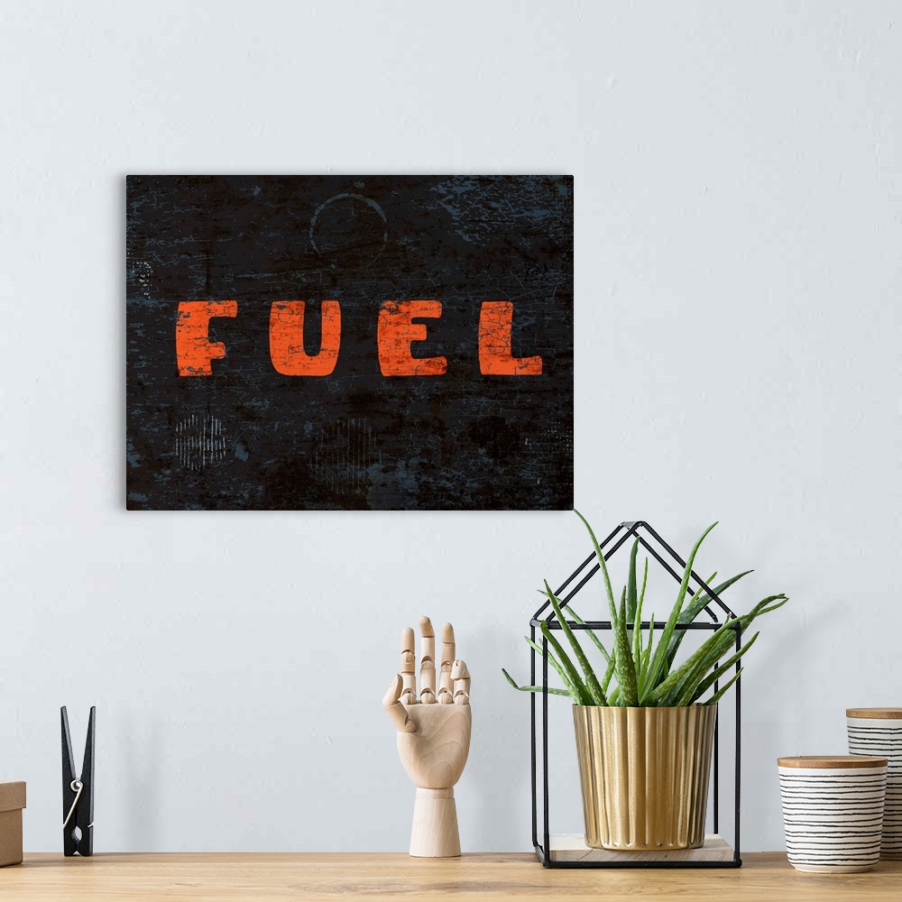 A bohemian room featuring Graphic rusty wall art of distressed typography with the the word FUEL large, in orange, and in c...