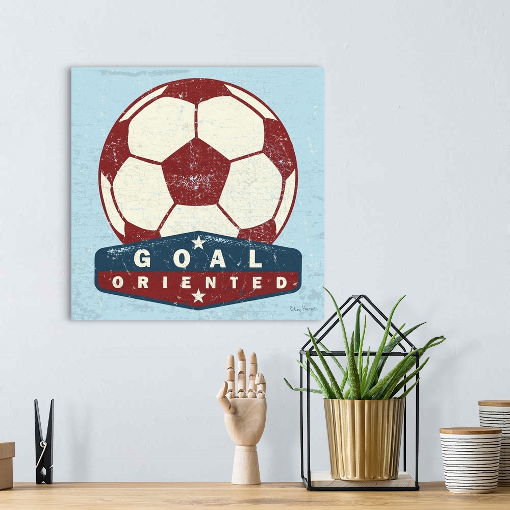 A bohemian room featuring Distressed  large red soccer ball with a typography saying Goal Oriented.