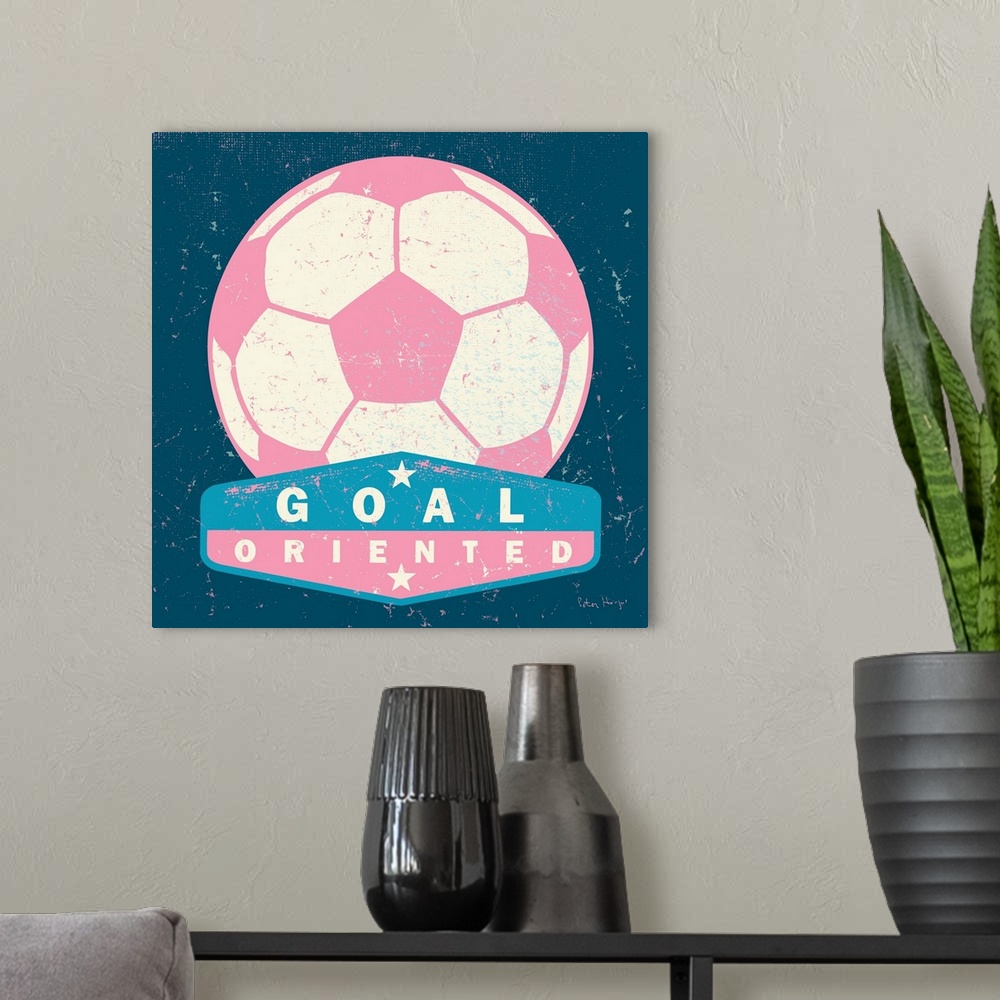 A modern room featuring Distressed large pink soccer ball with a typography saying "Goal Oriented"