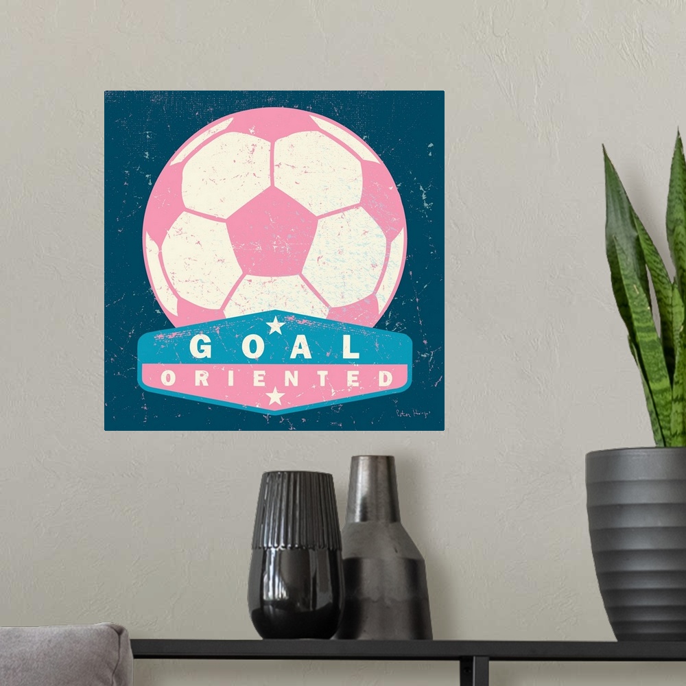 A modern room featuring Distressed large pink soccer ball with a typography saying "Goal Oriented"