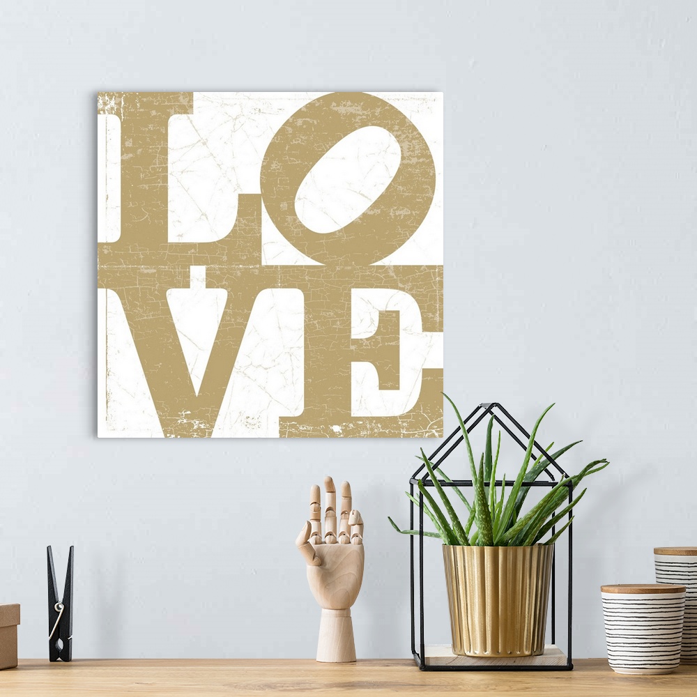 A bohemian room featuring A LOVE graphic with bold and distressed typography in gold.