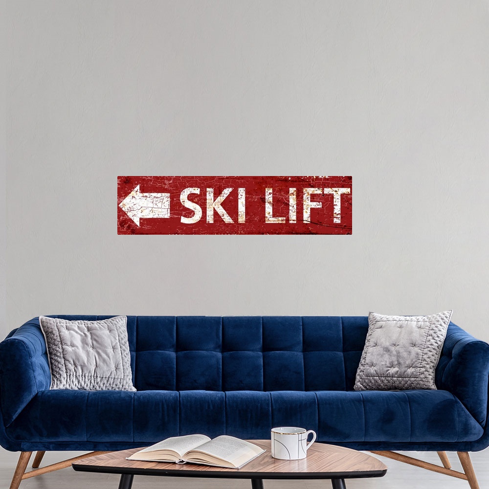 A modern room featuring A worn, distressed, cracked and rusty ski lift arrow sign in red.
