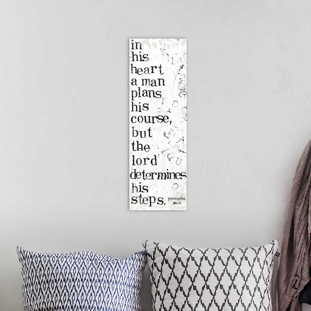 A bohemian room featuring Distressed black and white letter-stamped Bible verse scripture of Proverbs 16:9 In his heart a m...