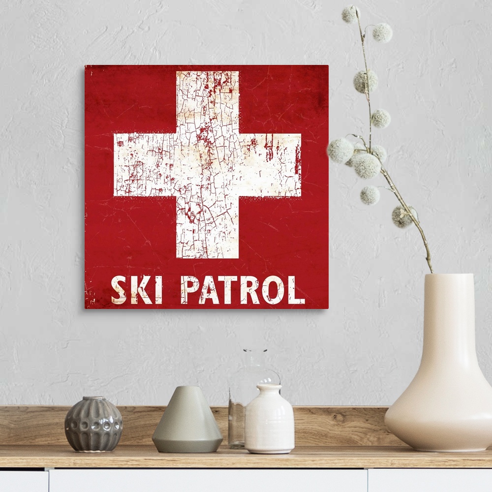 A farmhouse room featuring A worn, distressed, cracked and rusty Ski Patrol ski sign.