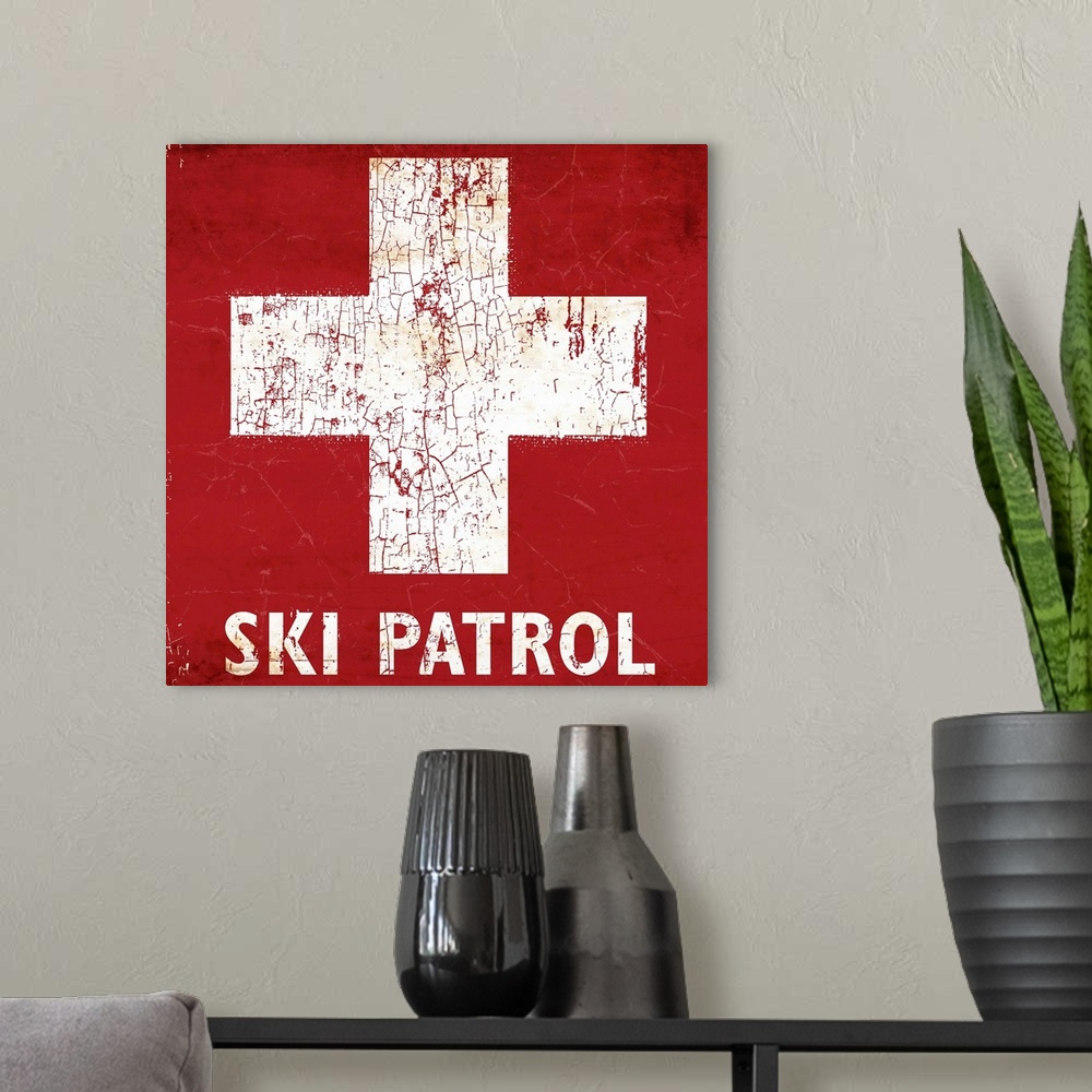 A modern room featuring A worn, distressed, cracked and rusty Ski Patrol ski sign.