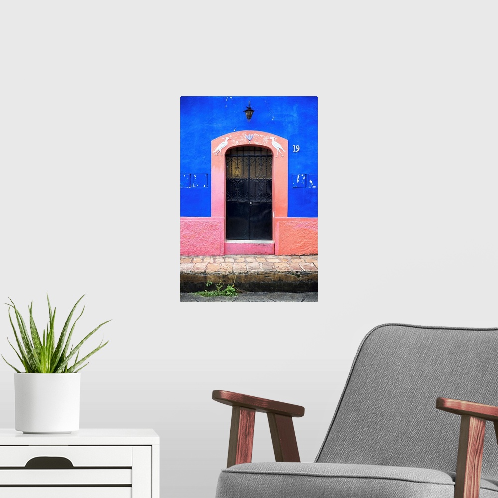 A modern room featuring Photograph of the blue and pink exterior to a building highlighting the doorway. From the Viva Me...